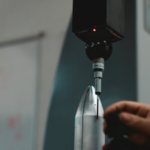 CMM probe inspecting a metal nose cone